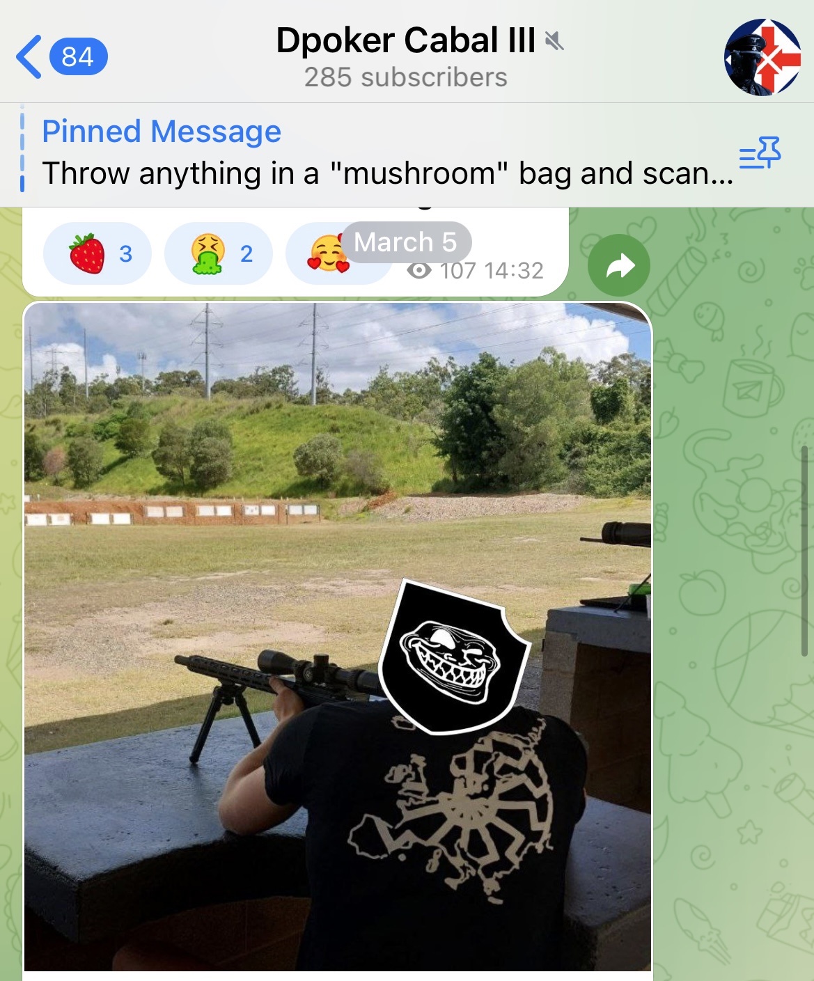 A screenshot from DPoker Cabal III Telegram channel of a post dated 5 March 2022. A photograph taken from behind shows a white male aiming a gun at a target at SSAA Brisbane in Belmont. He is wearing a black t-shirt with a Sonnenrad design printed on it. His head is covered by a trollface sticker.