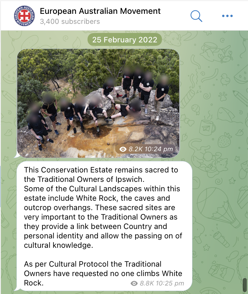 A screenshot of the European Australian Movement Telegram channel and a post dated 25 February 2022. A photograph shows twelve neo-Nazis dressed in black posing for a photograph at the top of White Rock in Ipswich. They have carved a swastika into the rock, desecrating this sacred site. Below they have copy pasted this text to mock it. This Conservation Estate remains sacred to the Traditional Owners of Ipswich. Some of the Cultural Landscapes within this estate include White Rock, the caves and outcrop overhangs. These sacred sites are very important to the Traditional Owners as they provide a link between Country and personal identity and allow the passing on of cultural knowledge. As per Cultural Protocol the Traditional Owners have requested no one climbs White Rock.