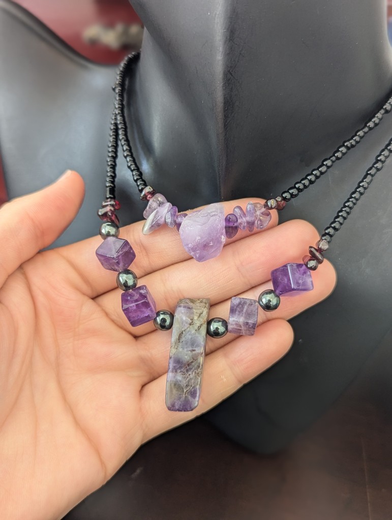 2 amethyst garnet necklaces with a real amethyst gemstone and polished on with this gemstone and Amethyst cubes and have my dad's down the beads and the car net beads and black glass beads