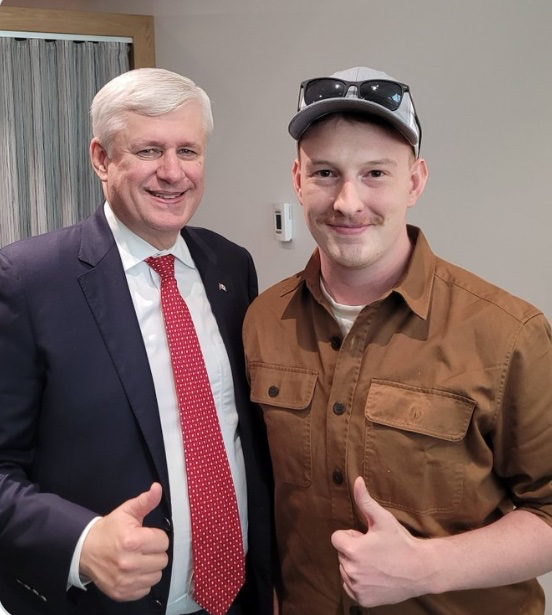 Stephen Harper and Keean Brexte, standing together, both showing a thumbs up and smiling