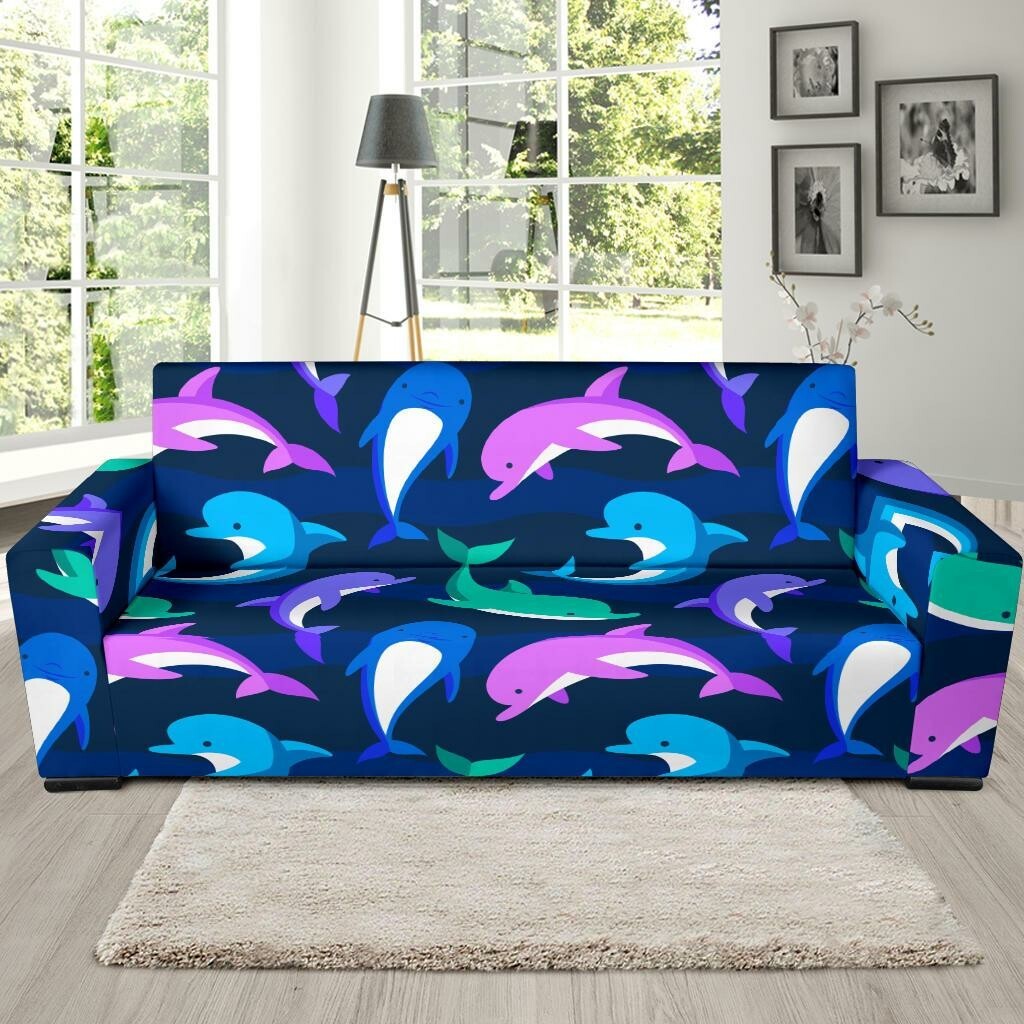 a sofa with a slipcover covered in dolphins images.