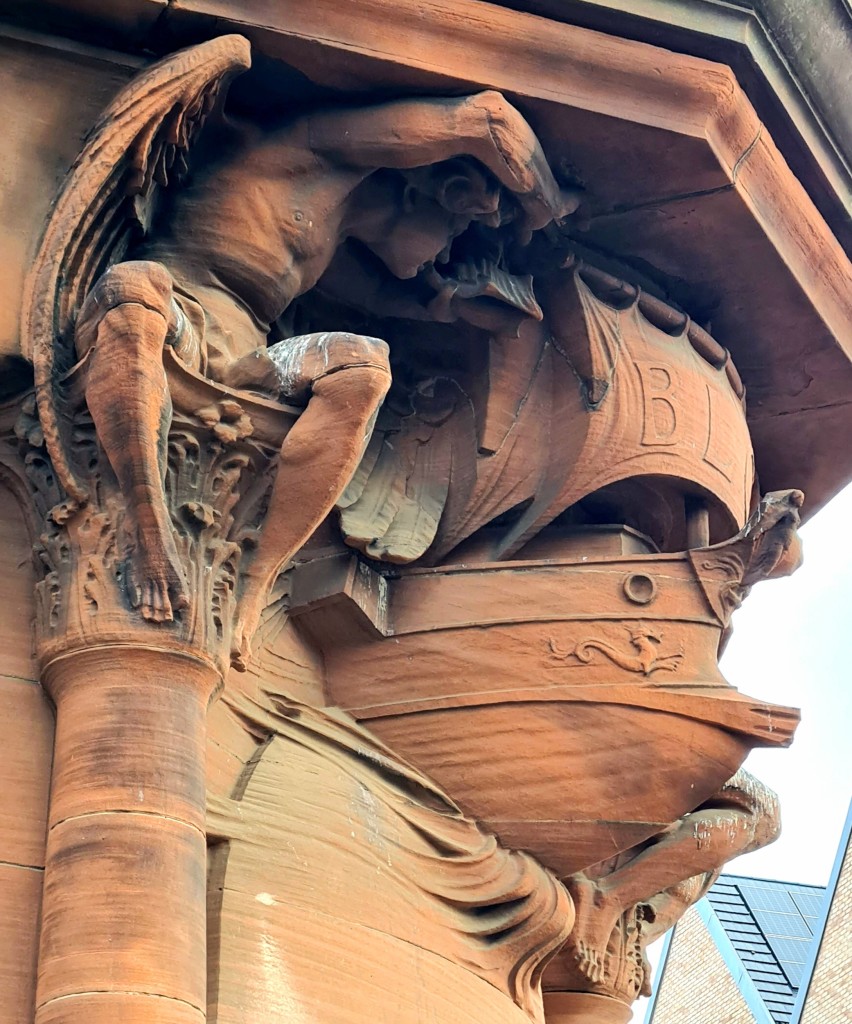 An ornate sculpture over thr door of a Victorian bank building.