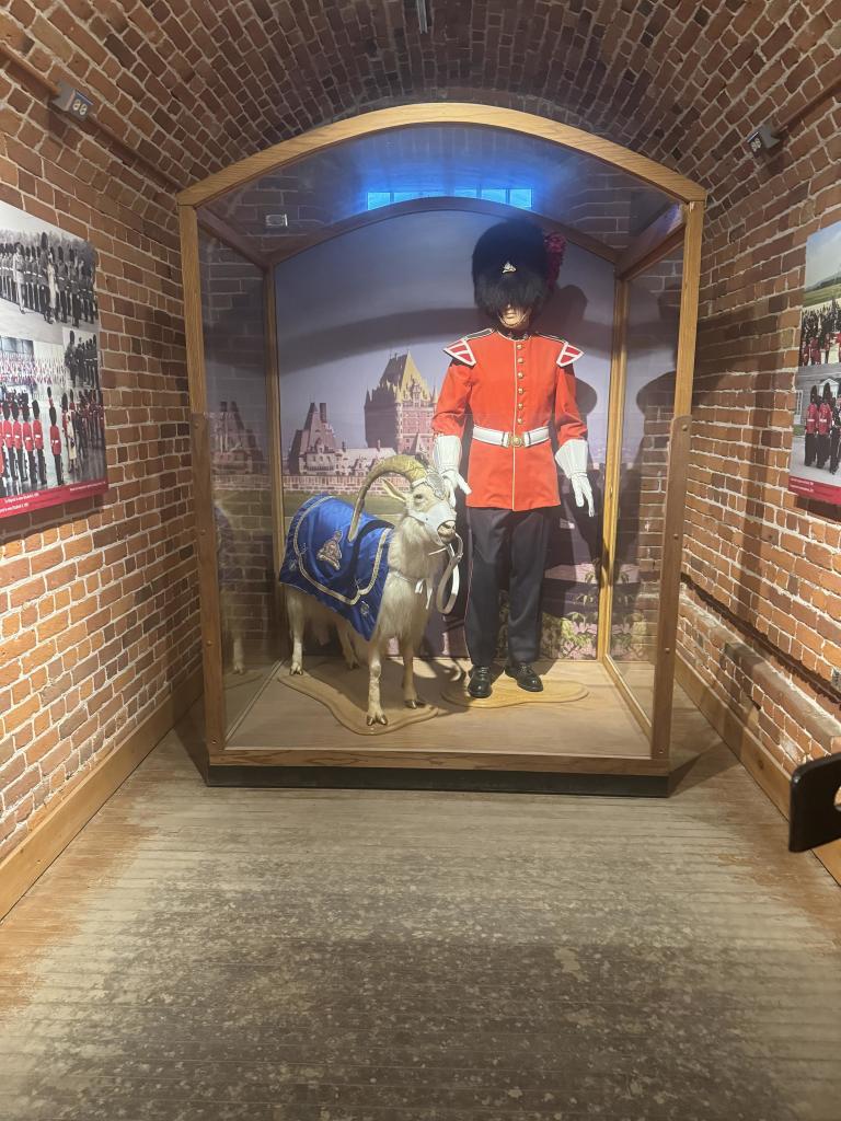 The picture shows the inside of a cell at the citadel of Quebec with a mannequin of a regimental soldier and the mascot ram. 