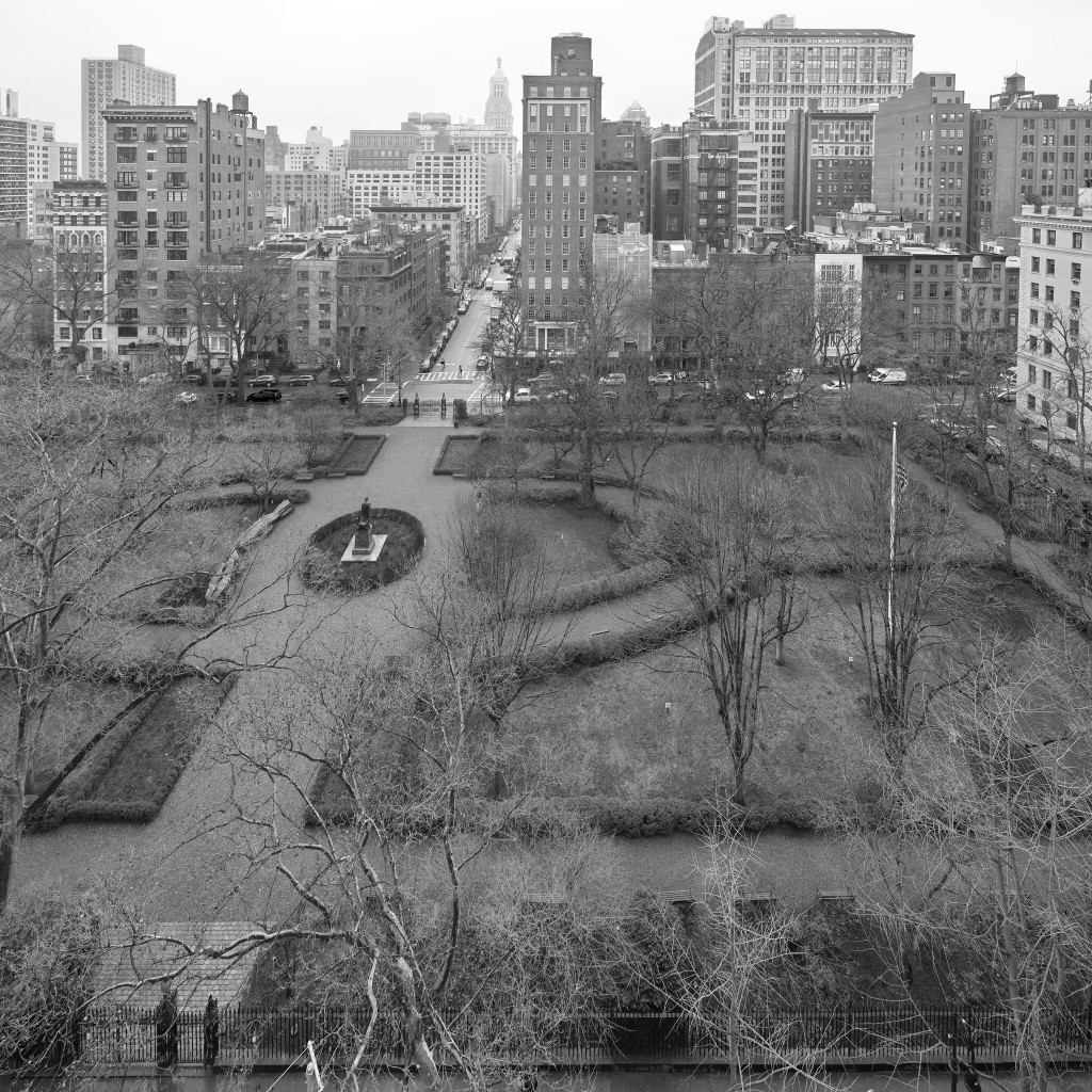 A small, formally landscaped urban park, surrounded by buildings. There are locked gates. There are no people in the park. Go away.