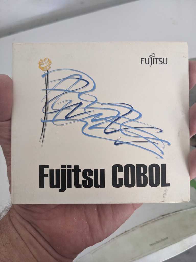 A cardboard cd wallet with an abstract blue flag and the text Fujitsu COBOL.