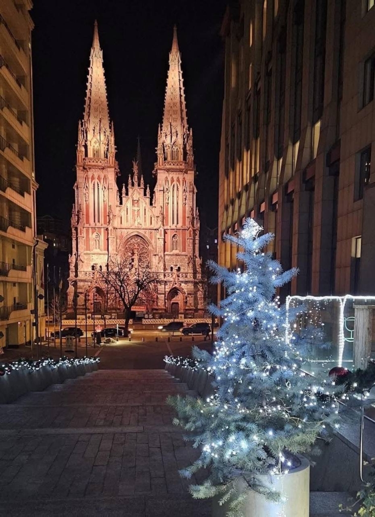 A historic church at night photographed from a nicely decorated street