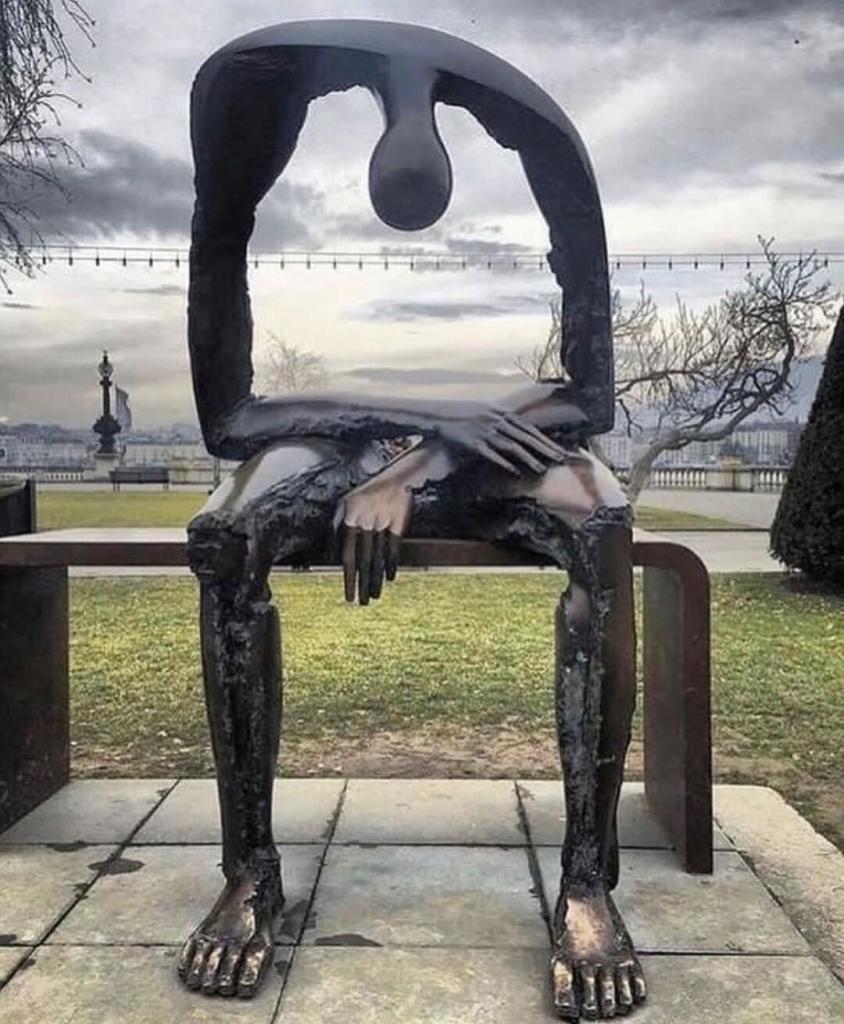 Sculpture. A bronze sculpture on the edge of Lake Geneva with the title: "Melancholy". The bronze sculpture is a life-size man sitting on a wooden bench. His stomach is missing, he consists of arms, legs and head. There is a hole in the place of his upper body through which you can see the lake behind him. His small head is lowered and his arms are crossed on his bare thighs. Everything about this sculpture expresses sadness and despair. 
Info: The photo was chosen to express deep sympathy to the victims and relatives of the terrorist attack on a Christmas market in Magdeburg on December 20, 2024. 