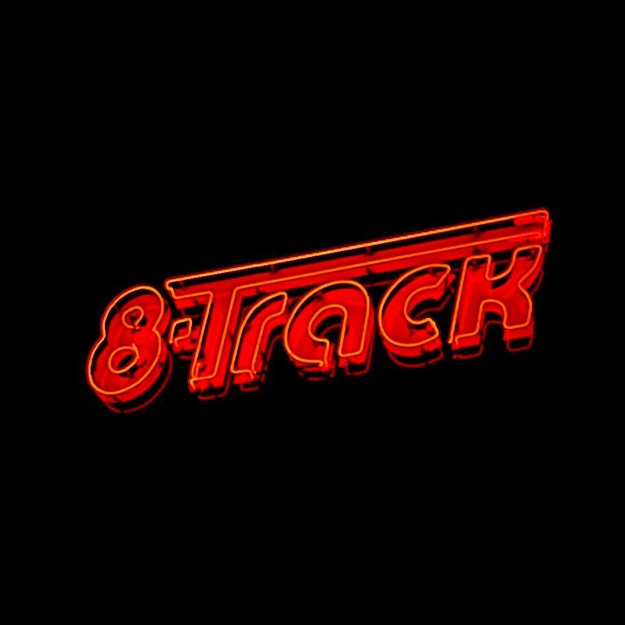 Red neon sign for a bar called 8-Track. It's nighttime so everything else is black