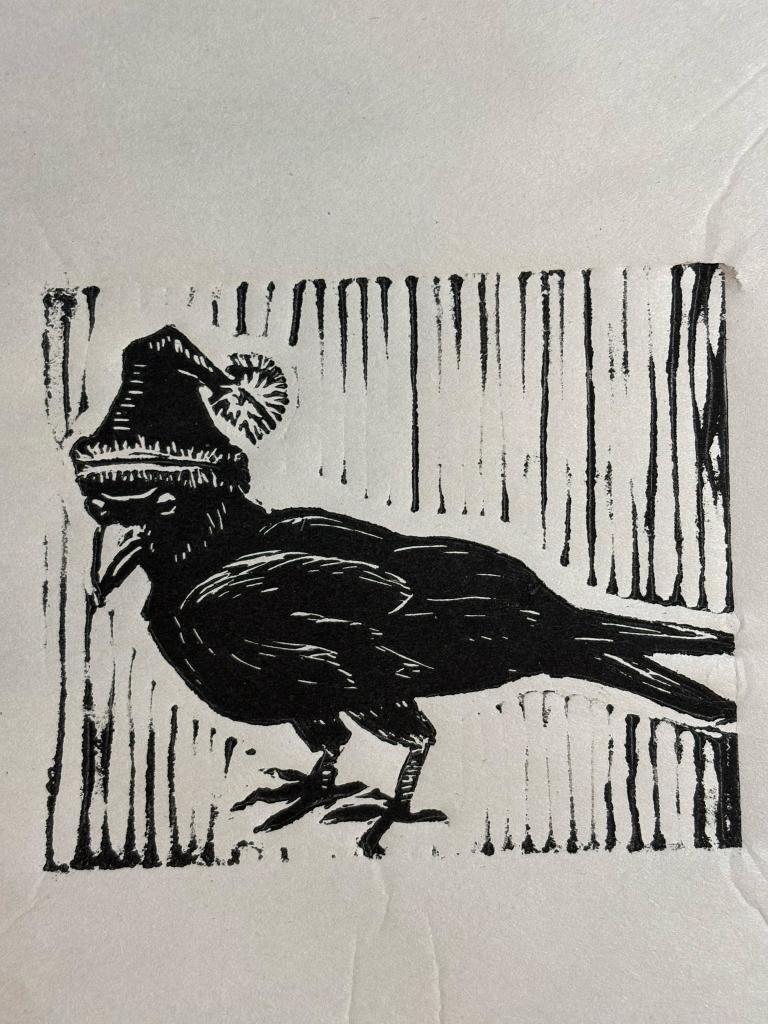 Linocut print of a crow in a Santa hat