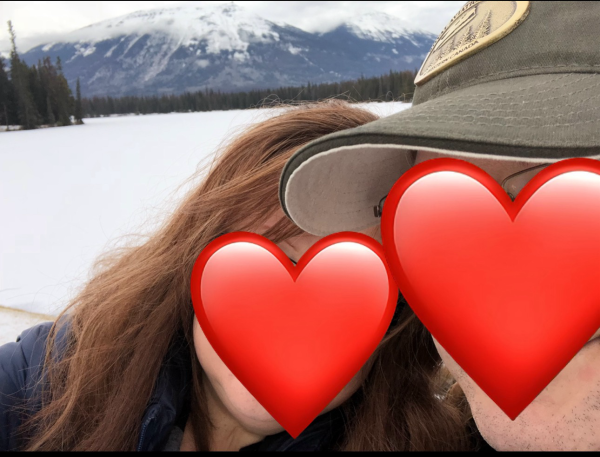 BunMum and Dad smile in front of a snow covered lake in the mountains.