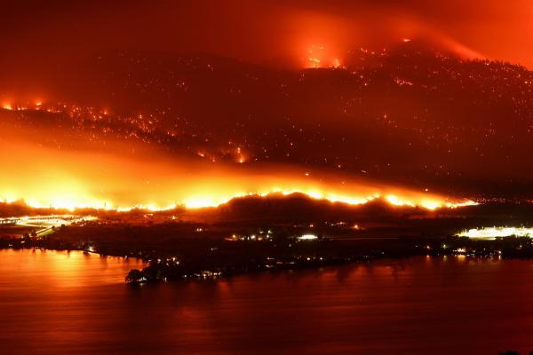 Town on the edge of a lake in BC . Another photo in orange fire in the sky against black hills and city.