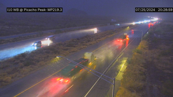 Camera showing 18 wheelers... speeding along the freeway, wipers on full, country music running, and crackle on channel 19 on the CB about some wet roads ahead. Don't slow down, can't be late, pass the 4 wheel drivers going only 68.