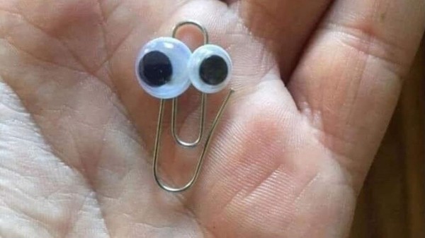 Open palm containing a paperclip with googly eyes that looks like Microsoft virtual assistant Mr Clippy