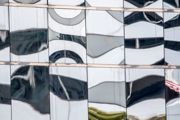 Glass on the side of a Building showing distorted reflections.