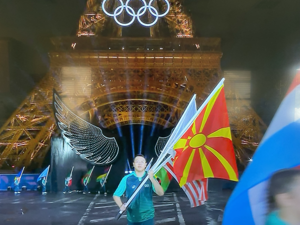 Base of the Eiffel Tower as flags of nations emerge between the wings of dove of peace