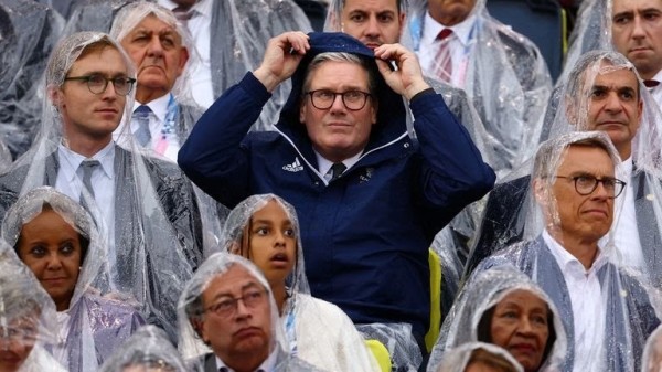 Keir Starmer in good quality waterproof jacket while the rest of Olympic VIPs have to make do with free waterproofs.