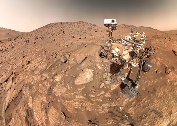 NASA’s Perseverance Mars rover took this selfie on July 23, 2024, the 1,218th Martian day, or sol, of the mission. To the left of the rover near the center of the image is the arrowhead-shaped rock nicknamed “Cheyava Falls,” which has features that may bear on the question of whether Mars was home to microscopic life in the distant past. The small dark hole in the rock is where Perseverance took a core sample, which is now in a sample tube stored in the rover’s belly. The white patch to the right of the hole is where the rover used an abrasion tool to clear away the top surface, allowing science instruments to study the rock’s composition.