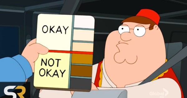 Family Guy screenshot with the skin color chart. Peter Griffin is driving a car and wearing done kind of Arabic clothes and a red hat (a fez?). Another guy (a policeman? But only the arm is visible) is holding a color chart next to him. Lighter skin tones labeled as OKAY and darker ones as NOT OKAY.