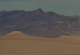 A Zoomed photo of what appears to be the same small peak in the small range of mountains in the background of the second photo above