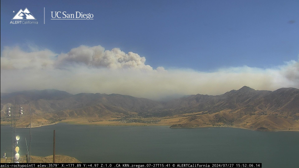 Smoke rising over a large lake, starting to form a pyroculumus