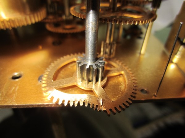 A clock gear wheel with the brass wheel part or Benton mangled from the main spring exploding