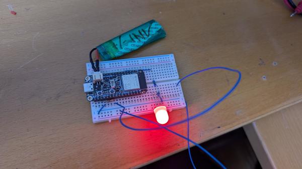 Electronics on a breadboard, a big red led shines bright.
There is a LIPO battery