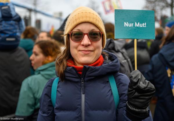 Demoteilnehmerin bei „Wir sind die Brandmauer“ mit einem Schild „Nur Mut!“. Kundgebung gegen den Faschismus, Berlin, 03.02.2024