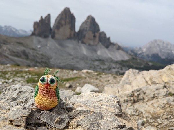 A knitted owl in front of the Tre Cime di Lavaredo