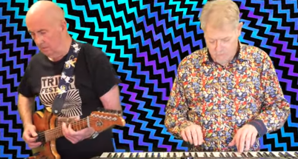 Henry Kaiser plays guitar, Bob Bralove plays keyboard, in front of wavy background