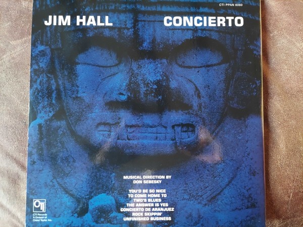 Superimposed on an image of (possibly) an Aztec god sculpture:
Jim Hall
Concierto
Musical Direction by Don Sebesky
You'd be So Nice to Come Home To
Two's Blues
The Answer is Yes
Concierto de Aranjuez
Rock Skippin'
Unfinished Business