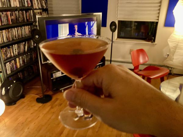 A Manhattan cocktail. Our apartment in the background with Josh Brolin on the screen and shelves of movies.