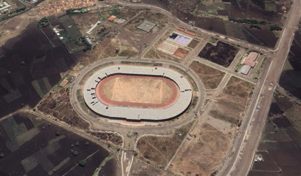 Woldia Stadium shot from the sky, with stadium tiles falling apart and the football field's grass brown from neglect.