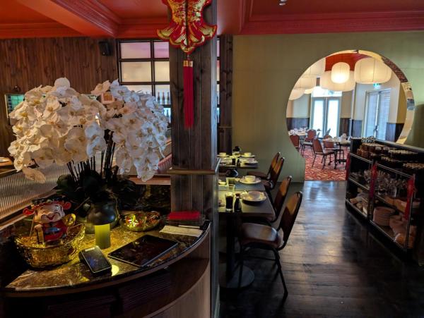 The entrance of the restaurant flowers, tables chairs