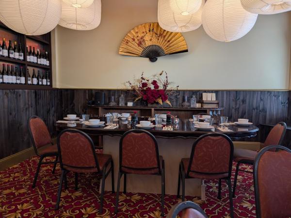 Empty table and chairs with a fan on the wall