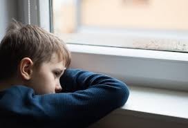 Sad kid looks out the window