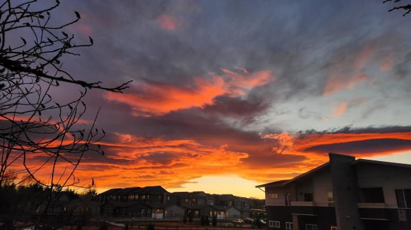 A fiery Colorado sunset. Longs Peak is barely visible between buildings. 