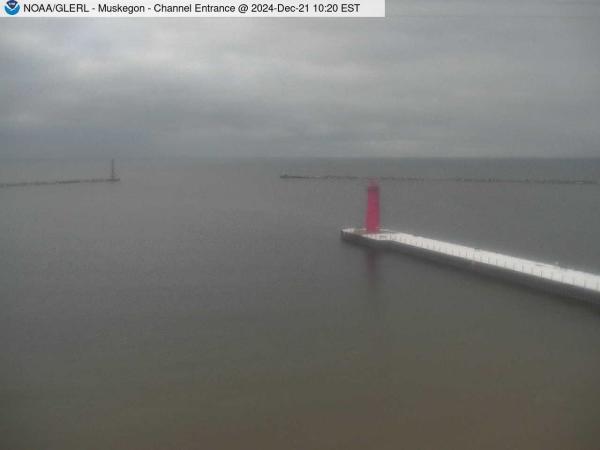 View of Muskegon breakwater in the distance, and the red South Lighthouse defining the entrance of the Muskegon Channel in the foreground. // Image captured at: 2024-12-21 15:20:01 UTC (about 13 min. prior to this post) // Current Temp in Muskegon: 24.26 F | -4.30 C // Precip: overcast clouds // Wind: NNE at 10.357 mph | 16.66 kph // Humidity: 67%