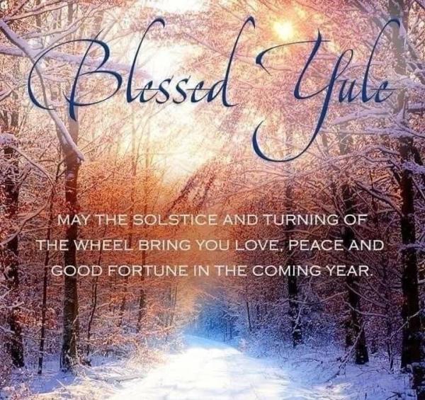 Photo of a snowy path through tall snow-drenched trees with the sun breaking through the branches. Overlaid is the text: Blessed Yule. May the solstice and turning of the wheel bring you love, peace and good fortune in the coming year. 