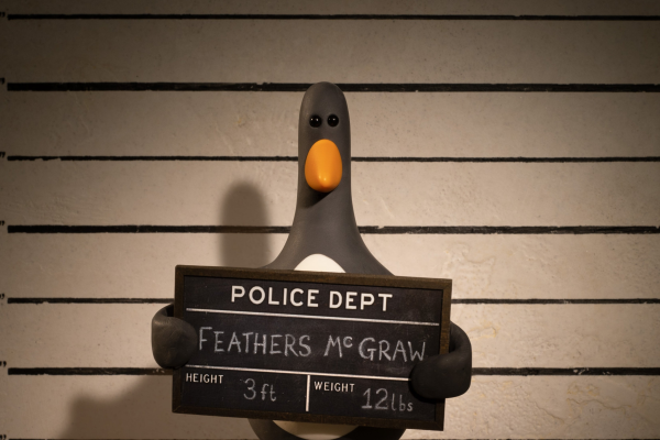 a claymation penguin with shifty eyes, holding a perp plaque from the local police department, stating his name, FEATHERS McGRAW; 3ft height, 12lbs weight