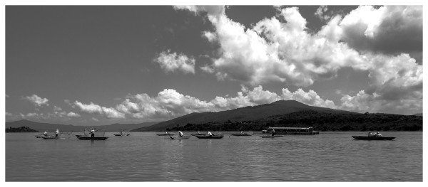 a B&W photo of a set of fishers in a calm morning over the janitzio lake, Michoacan Mexico.