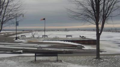 View looking northeast of the Oconto boat ramp and windsock in the foreground, with the breakwaters stretching into Sturgeon Bay behind it. // Image captured at: 2024-12-22 17:55:44 UTC (about 7 min. prior to this post) // Current Temp in Oconto: 24.89 F | -3.95 C // Precip: overcast clouds // Wind: S at 4.608 mph | 7.41 kph // Humidity: 58%